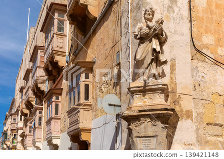 Religious statue on historic street facade in Valletta Malta 139421148