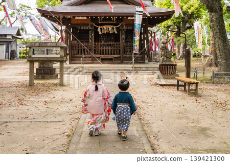 孩子們手牽手,沿著小路走向神社。 孩子們手牽手,沿著小路走向神社。 139421300