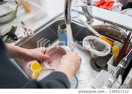 A woman's hands washing dishes A woman's hands washing dishes 139421312