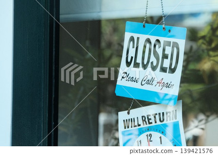 The "CLOSED" sign hanging on the shop window and its reflection in the glass. The "CLOSED" sign hanging on the shop window and its reflection in the glass. 139421576