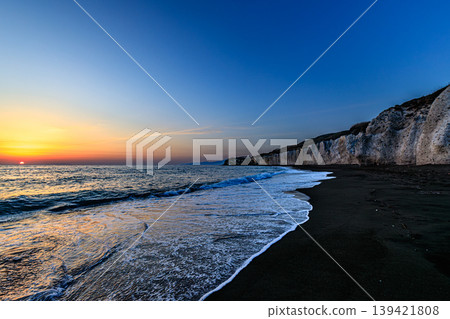 The waves gently lapping against the shore at Takise Beach at dusk. The waves gently lapping against the shore at Takise Beach at dusk. 139421808