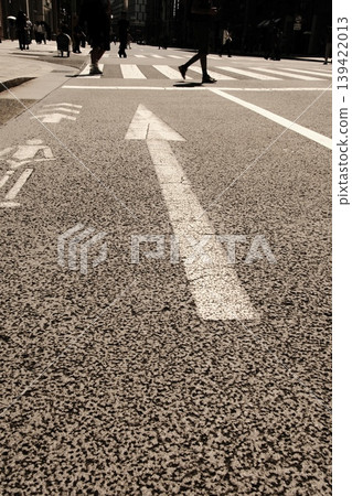 城市中前進的道路：路面上的箭頭和來往行人的腳步。 139422013