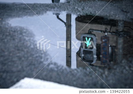 Pedestrian traffic light (green light) reflected in a puddle. Pedestrian traffic light (green light) reflected in a puddle. 139422055