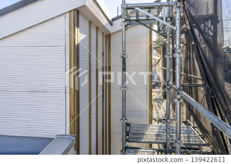 Exterior wall underlayment construction for a detached house; 2nd floor exterior wall with scaffolding. 139422611