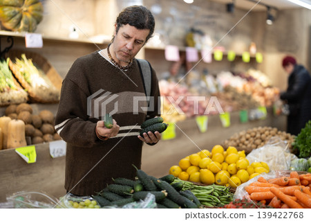 Grocery shopping - male shopper choosing vegetables on supermarket counter Grocery shopping - male shopper choosing vegetables on supermarket counter 139422768