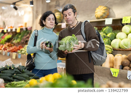 Married couple chooses ripe cabbage together in grocery supermarket 139422799