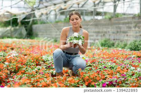 Young woman choosing flowers in greenhouse 139422893
