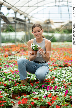 Young woman choosing flowers in greenhouse 139422915