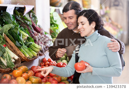 Husband and wife choose ripe tomatoes 139423378