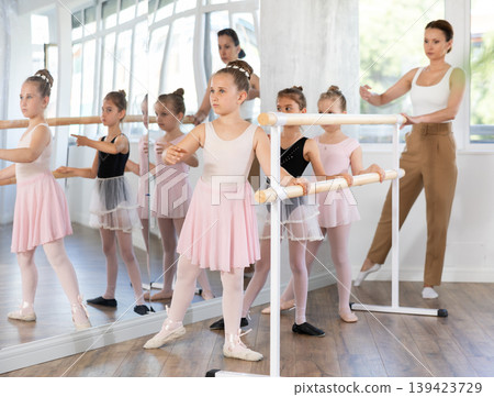 Girls in ballet class perform Batman with correction of female mentor 139423729