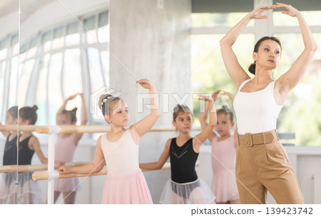 Teacher dancer performing pirouette in front of class Teacher dancer performing pirouette in front of class 139423742