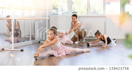 Little girls ballerinas learn to do the splits in dance class Little girls ballerinas learn to do the splits in dance class 139423756