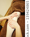 Close-up of a woman's feet receiving an oil massage on her calves at a spa. 139424865