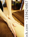 The scene shows a woman's calf being gently massaged with aromatherapy oil. 139424867