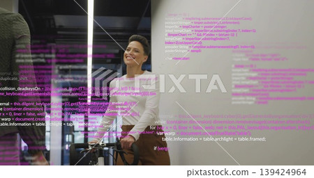 Smiling developer wearing white turtleneck standing behind bicycle in office with projected code Smiling developer wearing white turtleneck standing behind bicycle in office with projected code 139424964