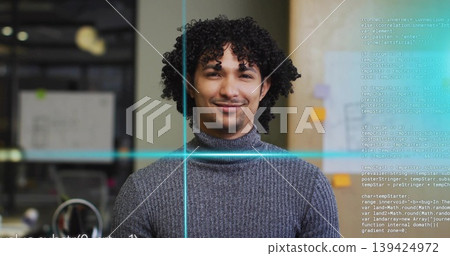 Smiling developer wearing grey sweater at office cubicle, with computer monitor and code overlay Smiling developer wearing grey sweater at office cubicle, with computer monitor and code overlay 139424972