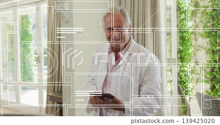 Standing senior medical professional holding tablet in sunlit sunroom, with digital overlays Standing senior medical professional holding tablet in sunlit sunroom, with digital overlays 139425020