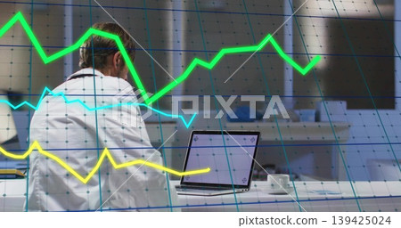 Male doctor in lab coat analyzing data on laptop in clinic, with coffee cup, stethoscope, graphs Male doctor in lab coat analyzing data on laptop in clinic, with coffee cup, stethoscope, graphs 139425024