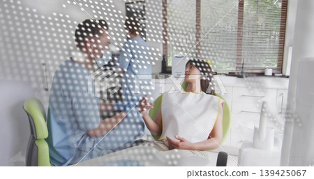 Leaning dentist consulting with patient in clinic, with green chair and instruments, copy space Leaning dentist consulting with patient in clinic, with green chair and instruments, copy space 139425067