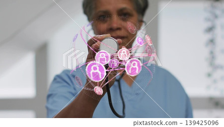 Doctor in scrubs holding stethoscope in hospital room, with holographic user profile padlock icons Doctor in scrubs holding stethoscope in hospital room, with holographic user profile padlock icons 139425096