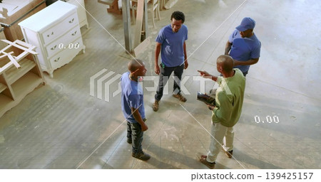 Discussing plans carpentry crew holding tablet and wearing boots in carpentry shop, with planks Discussing plans carpentry crew holding tablet and wearing boots in carpentry shop, with planks 139425157
