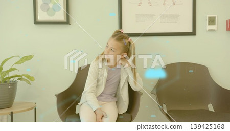 Waiting girl in reception, with black chairs, side table with plant, framed prints and thermostat 139425168
