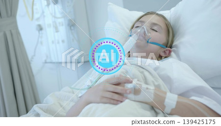 Resting pediatric patient wearing hospital gown and oxygen mask on bed in ward, with IV line 139425175