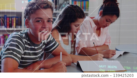 Three students writing in notebooks at library table, with digital overlay and bookshelf Three students writing in notebooks at library table, with digital overlay and bookshelf 139425203