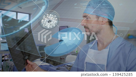 Surgeon in blue scrubs examining radiographic film in operating room, with holographic display Surgeon in blue scrubs examining radiographic film in operating room, with holographic display 139425285