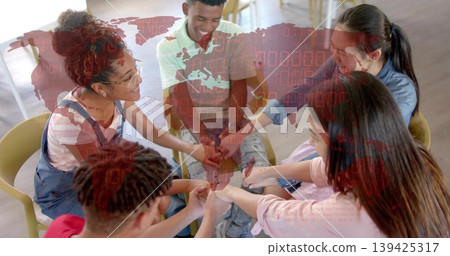Five students forming fist bump circle in meeting room, yellow chairs eyeglasses and digital map Five students forming fist bump circle in meeting room, yellow chairs eyeglasses and digital map 139425317