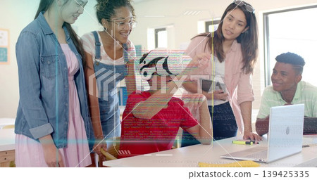 Interacting teen in red shirt wearing VR headset exploring VR content in classroom with instructor Interacting teen in red shirt wearing VR headset exploring VR content in classroom with instructor 139425335