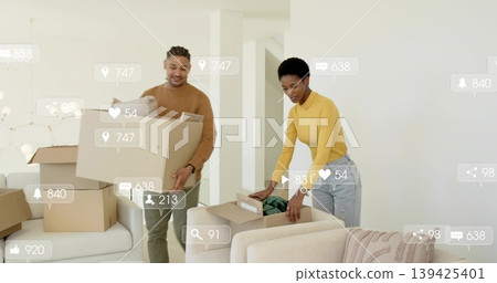 Unpacking couple in sweater and jeans sorting cardboard boxes in living room, with media icons Unpacking couple in sweater and jeans sorting cardboard boxes in living room, with media icons 139425401