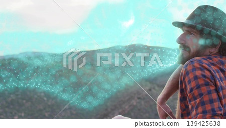 Leaning man in plaid, fedora on railing at mountain ridges view, with turquoise overlay, copy space 139425638