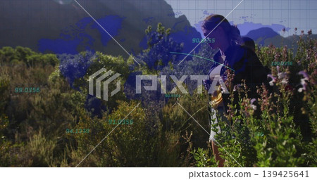 Surveying woman in dark jacket and shorts in mountainous scrubland with digital overlay, copy space 139425641