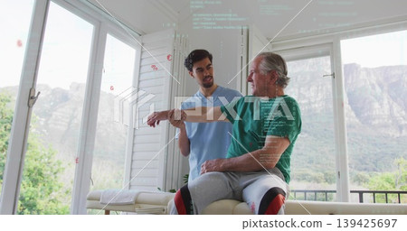 Stretching therapist in scrubs holding patient right arm on table in rehab, with braces, copy space Stretching therapist in scrubs holding patient right arm on table in rehab, with braces, copy space 139425697