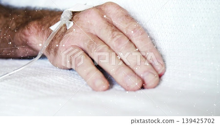 Showing senior patient hand resting on hospital bed, with catheter, medical tape, tubing and sheet 139425702
