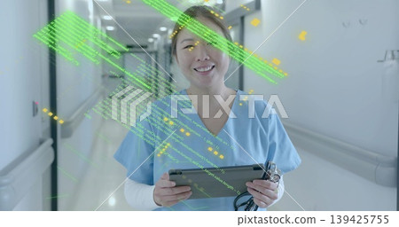 Smiling nurse in blue scrubs holding tablet, stethoscope in hospital hallway, with code overlay Smiling nurse in blue scrubs holding tablet, stethoscope in hospital hallway, with code overlay 139425755