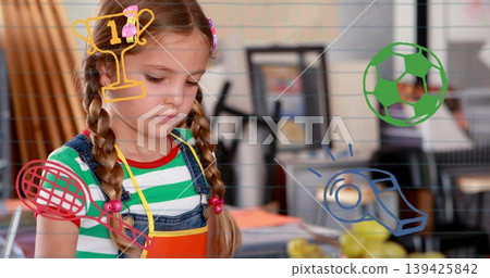 Cutting shapes schoolgirl in overalls and apron working at table in art room, with sports doodles 139425842