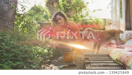 Kneeling woman planting orange marigolds from clay pot on path in backyard, with hand trowel Kneeling woman planting orange marigolds from clay pot on path in backyard, with hand trowel 139425849