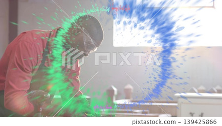 Shaping wood on lathe in workshop, wearing red shirt, goggles, digital swirl overlay, copy space Shaping wood on lathe in workshop, wearing red shirt, goggles, digital swirl overlay, copy space 139425866