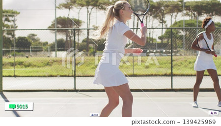 Holding racket tennis player in white skirt preparing to return shot on outdoor court with fence Holding racket tennis player in white skirt preparing to return shot on outdoor court with fence 139425969