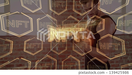 Lifting male wearing tank top doing bicep curl, gripping dumbbell in gym, with NFT hexagon graphics Lifting male wearing tank top doing bicep curl, gripping dumbbell in gym, with NFT hexagon graphics 139425986