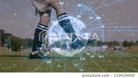 Female soccer player in knee-high socks kicking ball on pitch, holographic globe overlay with data Female soccer player in knee-high socks kicking ball on pitch, holographic globe overlay with data 139426000