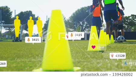 Dominating foreground, bright yellow cone leading drill on grassy pitch, mannequins, bibs, overlays 139426002