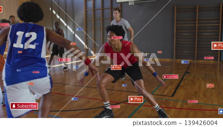Defending center player in red tank top crouching on hardwood court, with hoop and digital overlays 139426004