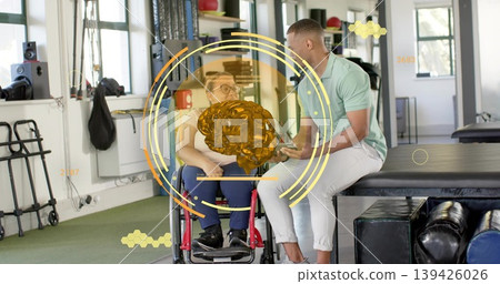 Discussing patient in red wheelchair, therapist holding tablet, viewing AR brain hologram in clinic Discussing patient in red wheelchair, therapist holding tablet, viewing AR brain hologram in clinic 139426026