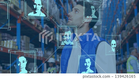 Warehouse worker in blue vest scanning boxes with handheld scanner in aisle, holographic panels 139426165