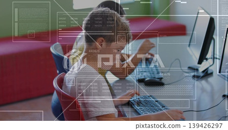 Working elementary students typing code on desktop monitors in coding lab, with digital overlays Working elementary students typing code on desktop monitors in coding lab, with digital overlays 139426297