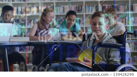 Smiling child boy in wheelchair reading open yellow book at study table in library, copy space Smiling child boy in wheelchair reading open yellow book at study table in library, copy space 139426299