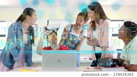Holding VR headset, teenage boy in red T-shirt sharing demo in lab with laptop and markers Holding VR headset, teenage boy in red T-shirt sharing demo in lab with laptop and markers 139426365